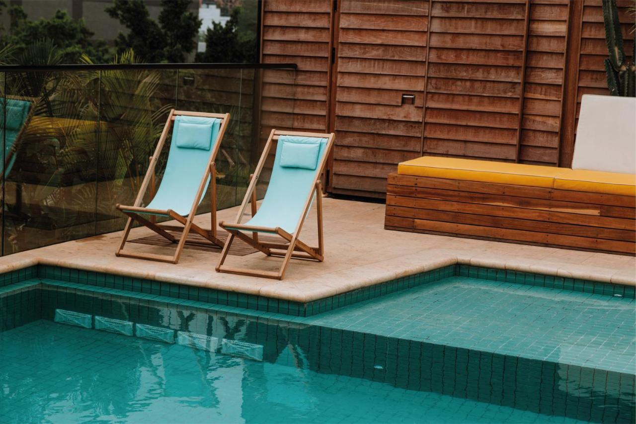 The Click Clack Hotel Medellín Exterior foto A pair of deck chairs by a pool